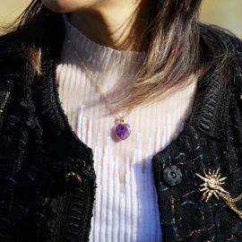 Collier en pierre naturelle d'améthyste porté avec un pull blanc