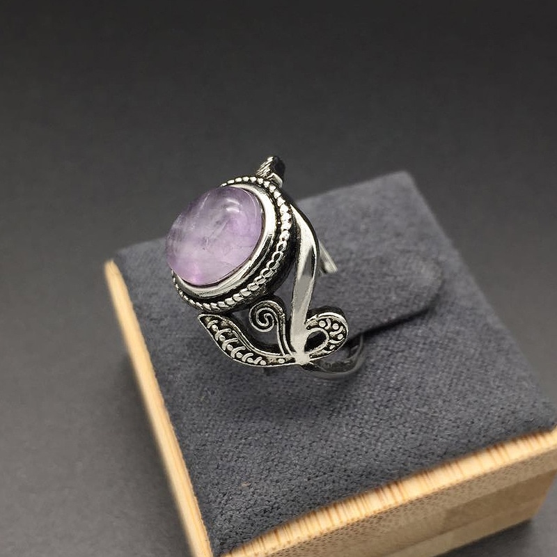 bague argent avec gravures et grosse pierre violette posé dans son écrin gris