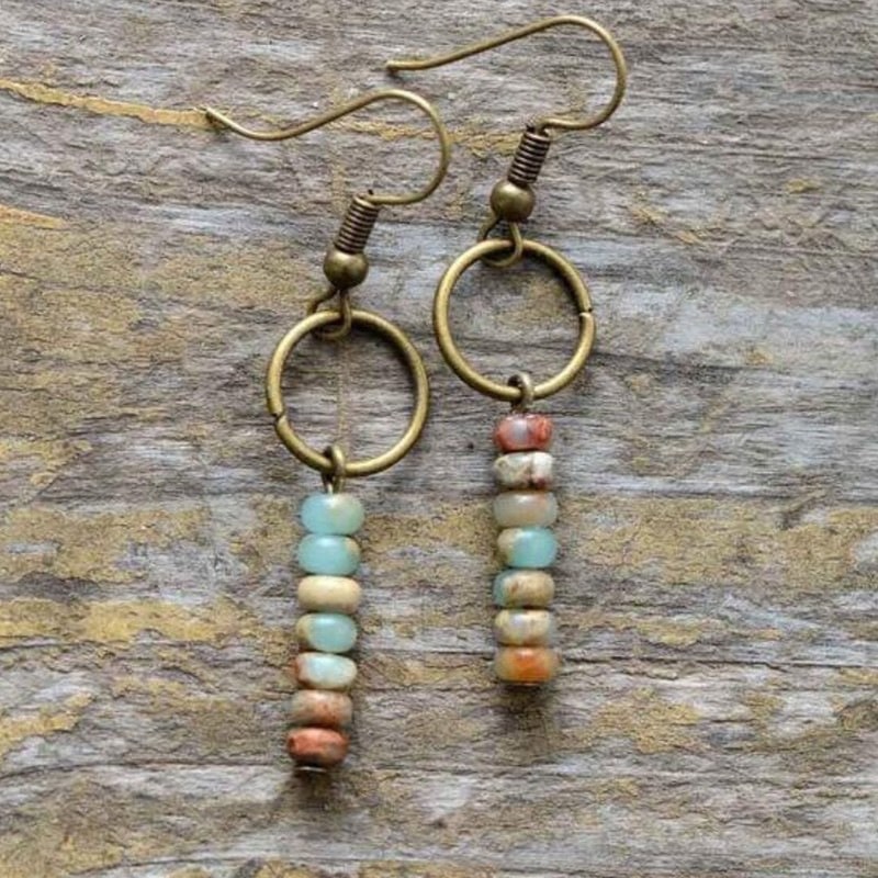 Boucles d'oreilles vintage en pierres naturelles japonaises empilées sur fond gris et beige