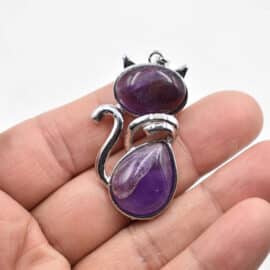 Lot de Dix Pendentifs Pierre Naturelle en Forme de Chat sur fond blanc dans une main